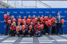 Pracownicy Politechniki Rzeszowskiej w czerwonych strojach, z czerwonymi balonami, 